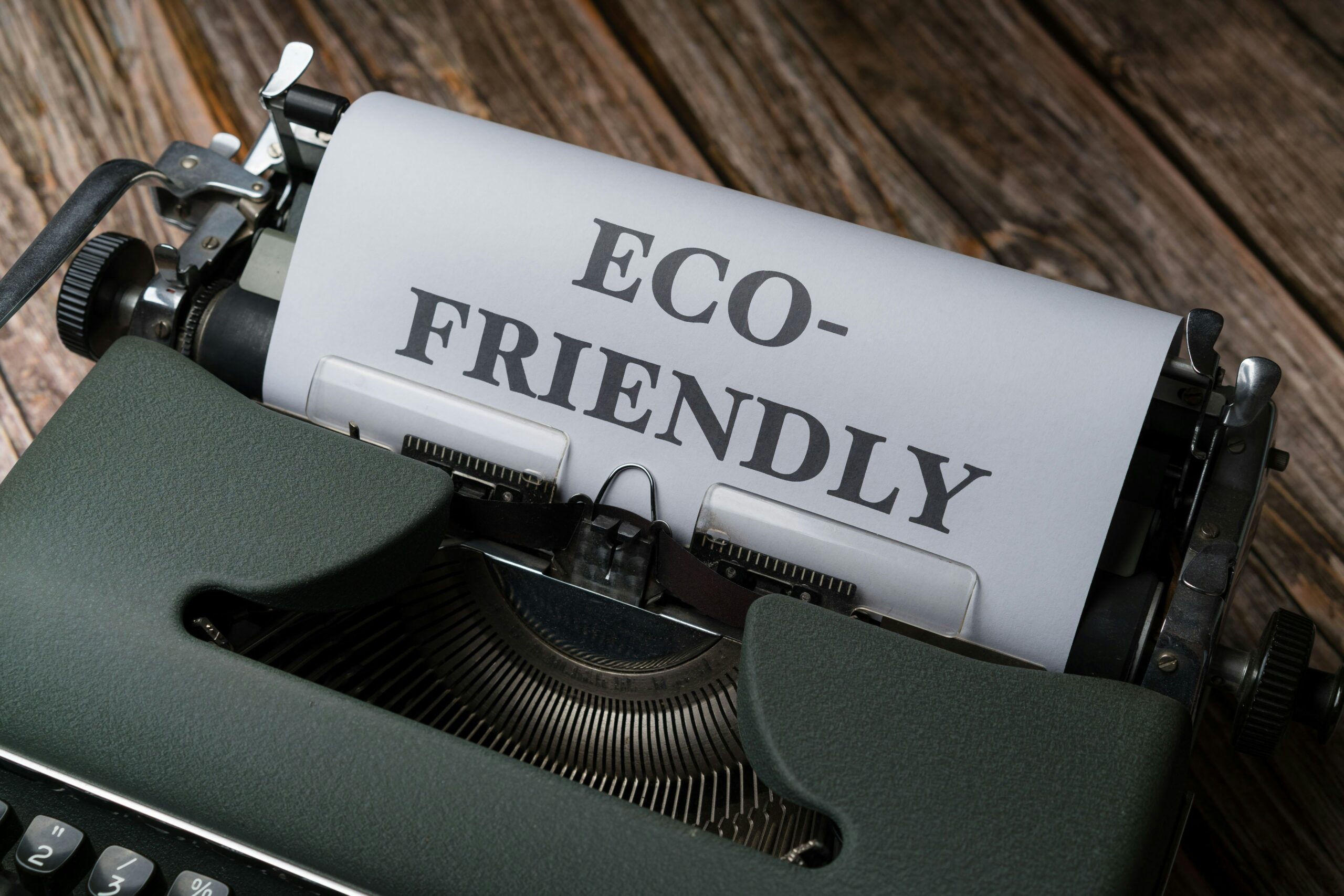 a close up of a typewriter with a paper that reads eco - friendly